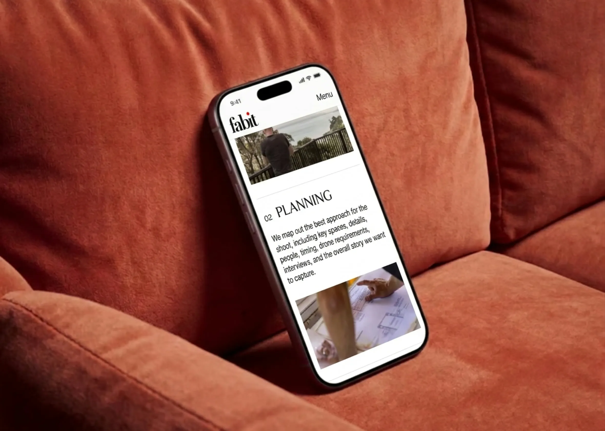 A Fabit article open on a phone resting on a rust-coloured sofa.